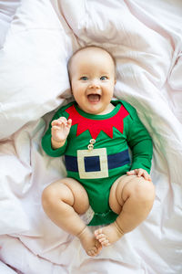 Portrait of cute baby girl lying down on bed