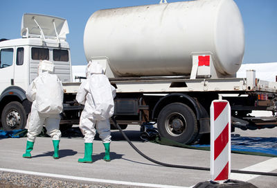 Rear view of workers walking towards vehicle