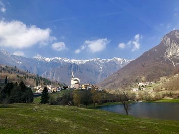 Scenic view of residential district by mountain against sky