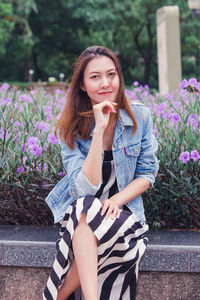 Portrait of beautiful young woman against white wall
