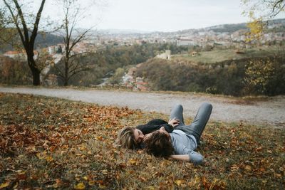 Couple lying on grass during autumn