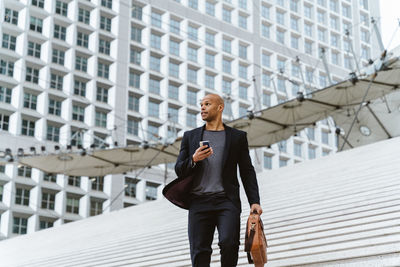 Portrait of businessman standing against building