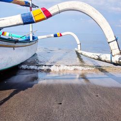 Boats moored on beach against sky