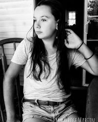 Young woman looking away while sitting at home