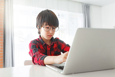 Young woman using laptop at home