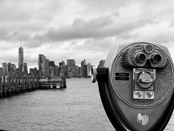 View of new york city bay with buildings in city against cloudy sky