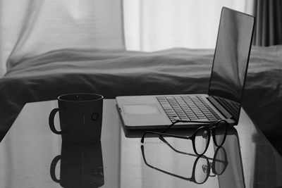 Close-up of laptop and mug on table