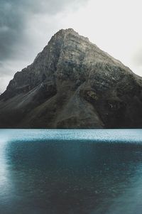 Swimming pool by mountain against sky