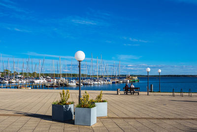 Street light by sea against blue sky