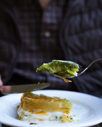 Close-up of person holding ice cream in plate