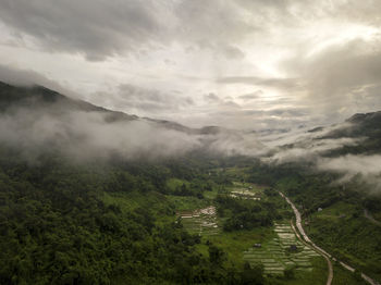 Aerial view of a village in the lush green rain cloud cover tropical rain forest mountain