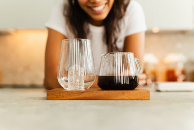 Midsection of woman holding wineglass on table