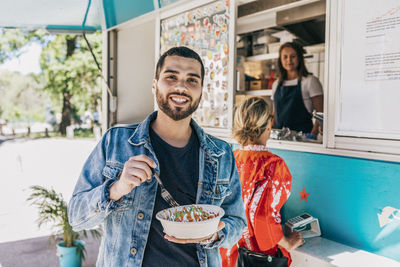 Portrait of a smiling young man eating food