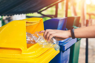 Midsection of woman holding yellow drink on table