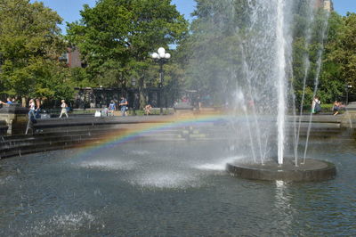 Fountain in city against sky