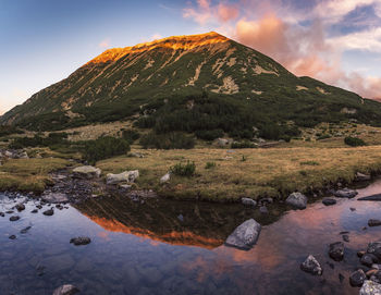 Scenic view of lake by mountain against sky