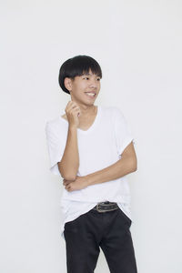 Portrait of young man standing against white background
