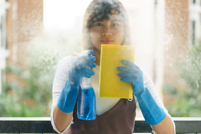 Portrait of woman drinking water from window