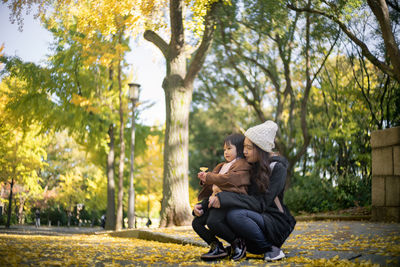 Young couple sitting in park during autumn