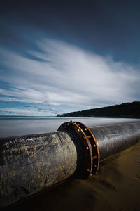 Pipeline at beach against sky