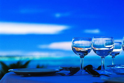 Wineglasses against sky on table at dusk