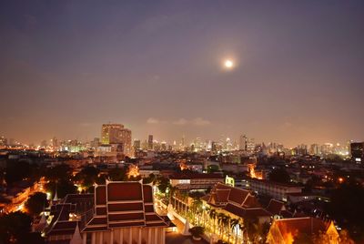 High angle view of illuminated buildings against sky at night