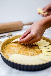 Close-up of person preparing apple pie