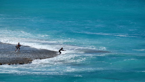 People surfboarding in sea