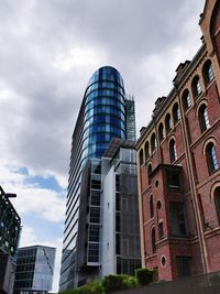 Low angle view of buildings against cloudy sky