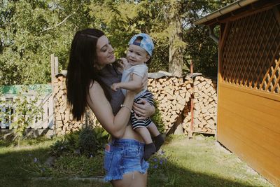 Young mother holding baby boy at yard