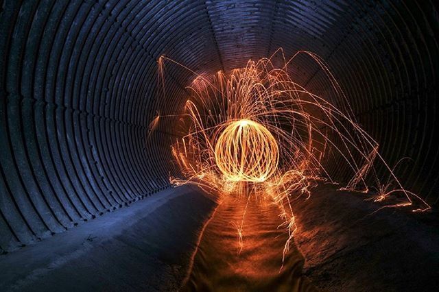 illuminated, night, long exposure, tunnel, motion, light trail, speed, blurred motion, rear view, spinning, men, lifestyles, unrecognizable person, the way forward, glowing, full length, leisure activity, pattern