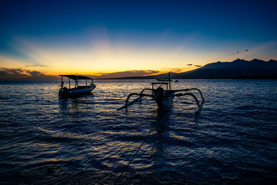 Silhouette boat in sea against sky during sunset