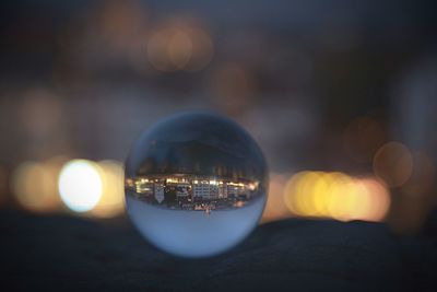 Close-up of illuminated crystal ball with reflection