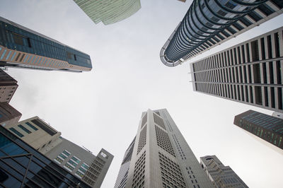 Directly below shot of modern buildings in city against clear sky