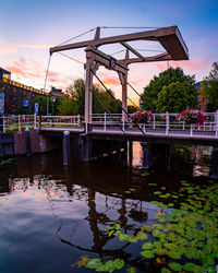 Bridge over river against sky during sunset