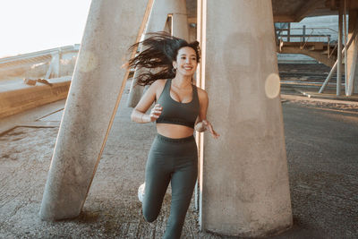 Full length of young woman standing against wall