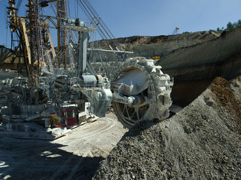 Bucket-wheel excavator at open-pit mine against clear sky