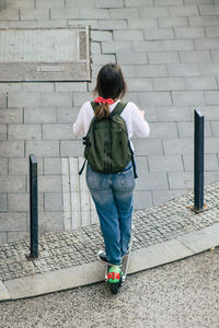 Rear view of woman standing on footpath