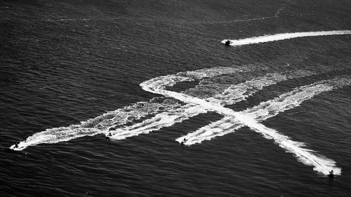 High angle view of people jet boating in sea