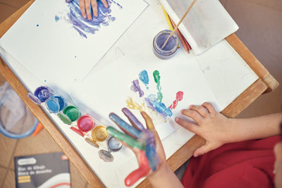 Children playing in an inner courtyard and painting with water paints