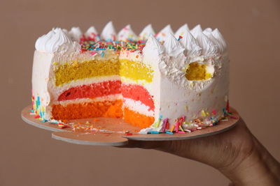 Cropped hand of woman holding cake