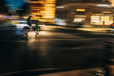 Uk, england, london, blurred motion of person riding motorcycle along city street at night