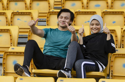 Portrait of friends sitting on seat