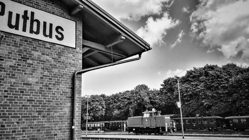 Low angle view of sign on road against sky