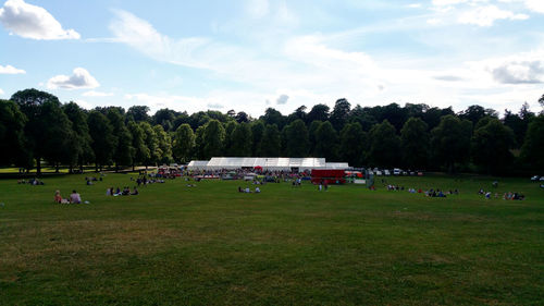 Group of people playing on field against sky