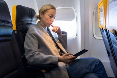 Young man using mobile phone while sitting in bus