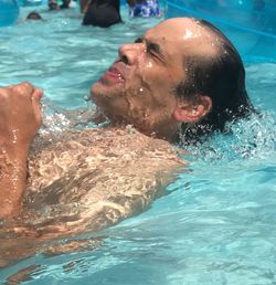 Close-up of shirtless boy swimming in pool