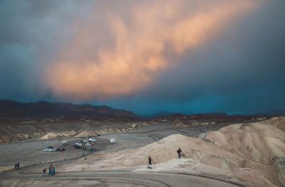 High angle view of people hiking at death valley national park against cloudy sky