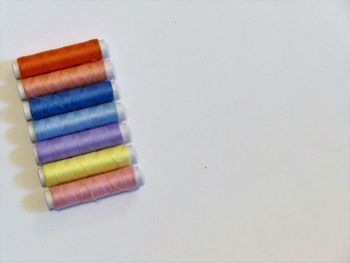 High angle view of multi colored pencils on white background