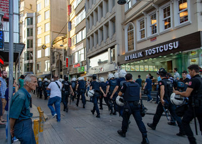 People walking on street amidst buildings in city